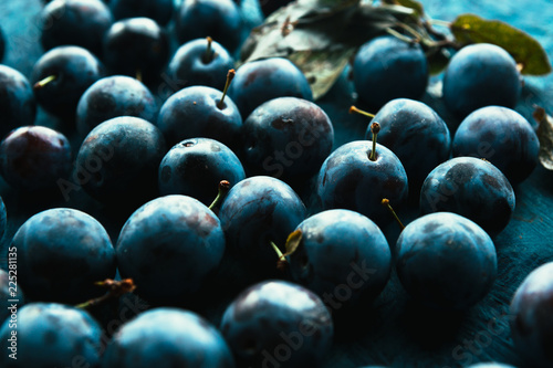 Obraz na płótnie many fresh plums on blue background close up.