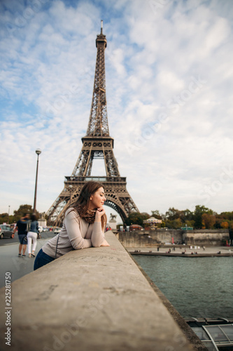 Beautiful young girl in front of eiffel tower. Girl is smiling and rejoising. autumn photo © Aleksandr
