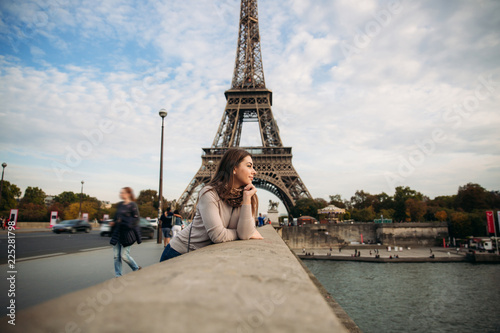 Beautiful young girl in front of eiffel tower. Girl is smiling and rejoising. autumn photo © Aleksandr