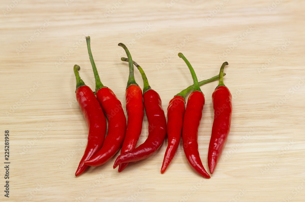 Chili pepper - The Chili pepper plants to the nature of the sphere of the long spikes of pale red, Chili peppers are widely used in many cuisines to add spiciness to dishes on wood table.