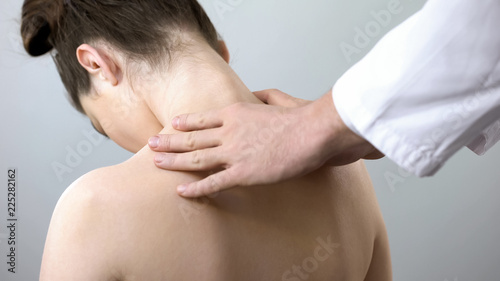 Neurologist touching female shoulders, doctor examining spine, healthcare