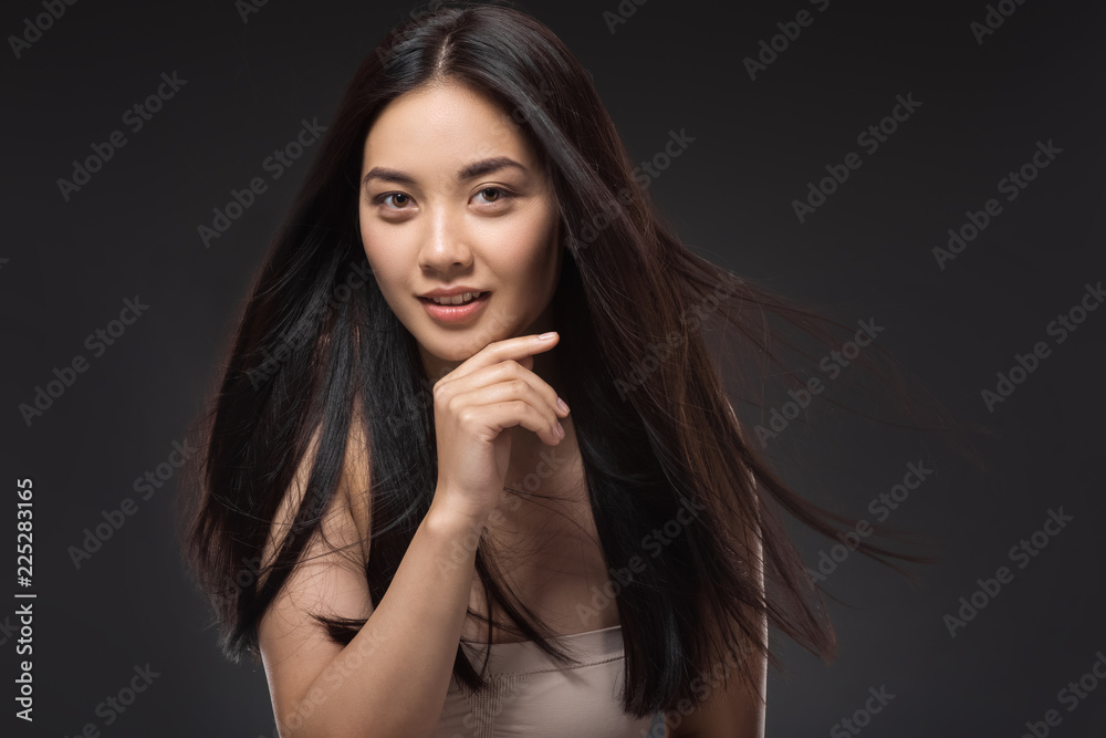 portrait of young asian woman with beautiful and healthy dark hair looking at camera isolated on black portrait of young asian woman with beautiful and healthy dark hair looking at camera isolated on black