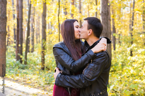 Relations, nature and love concept - Handsome man kissing beautiful woman in autumn nature © satura_