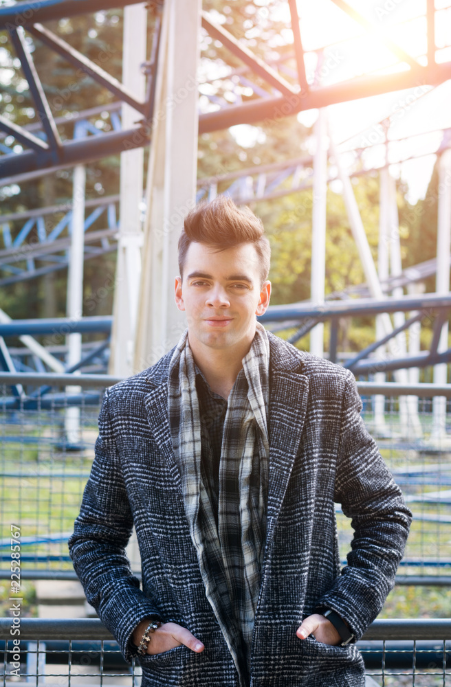 Portrait of a young beautiful man in an autumn coat