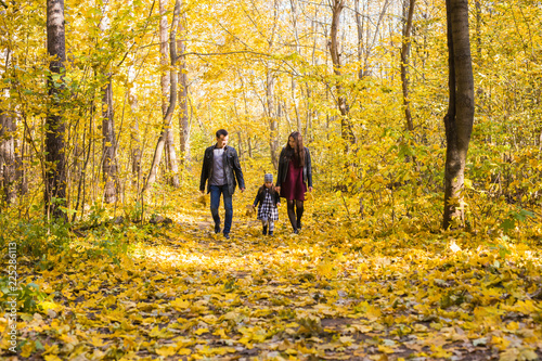 Family  autumn  people concept - young family walking in park on in autumn day