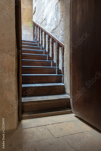 Open wooden door revealing wooden old staircase going up located at the House of Egyptian Architecture historical building, Cairo, Egypt