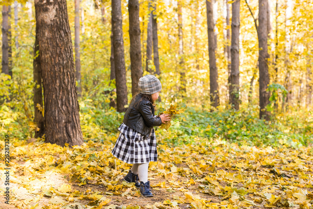 Autumn, seasons and children concept - happy little girl laughing and playing with fallen leaves in park Autumn, seasons and children concept - happy little girl laughing and playing with fallen leaves in park