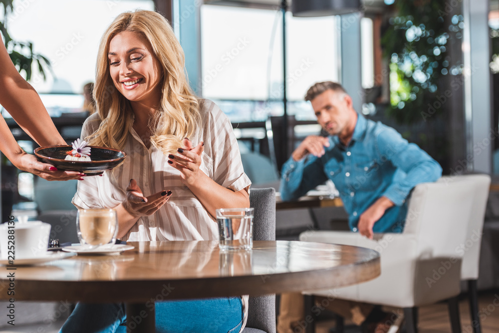 surprised beautiful woman looking at dessert with flower in cafe