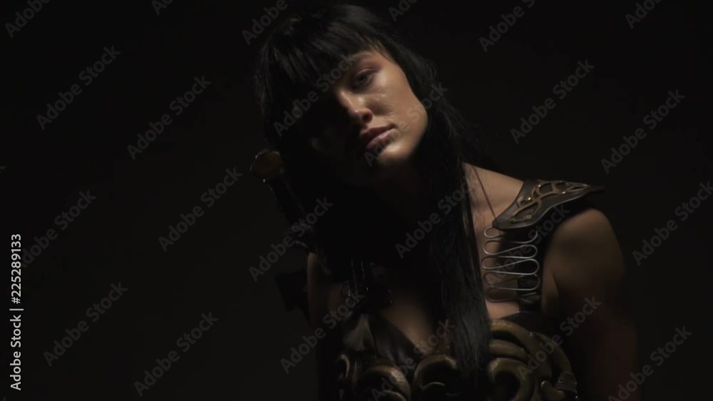 Busty Amazon in armor stands in the dark, slow motion Busty Amazon in armor stands in the dark, slow motion