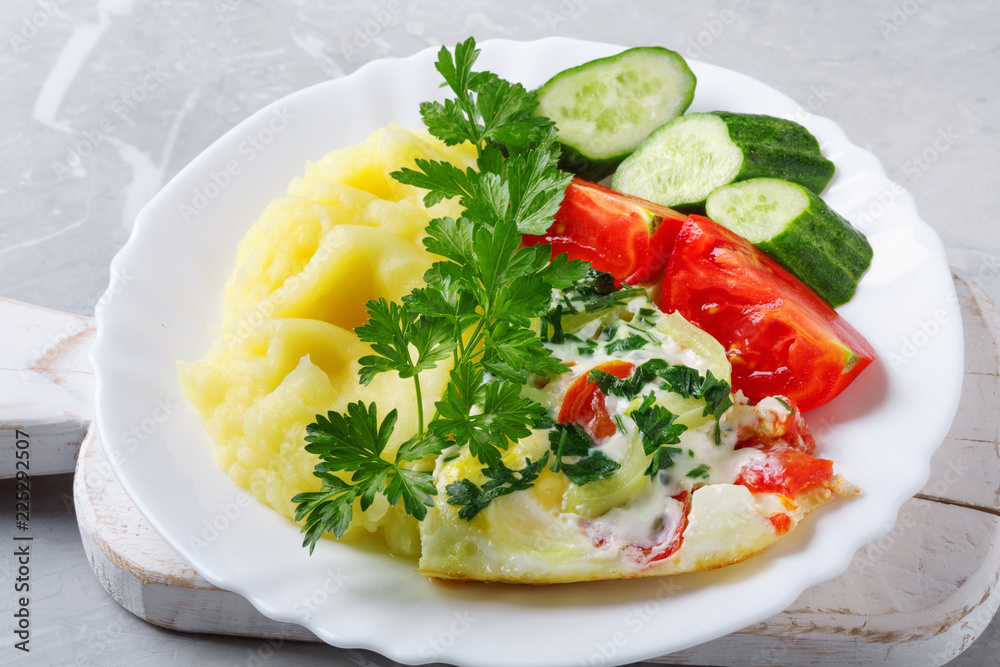 Hot tasty mashed potatoes with scrambled eggs, tomatoes, cucumbers and fresh parsley Hot tasty mashed potatoes with scrambled eggs, tomatoes, cucumbers and fresh parsley