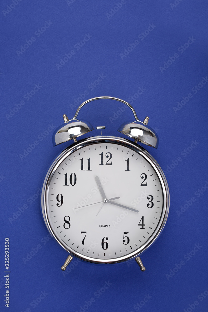 Top view of a classic alarm clock on dark blue background with copy space Top view of a classic alarm clock on dark blue background with copy space