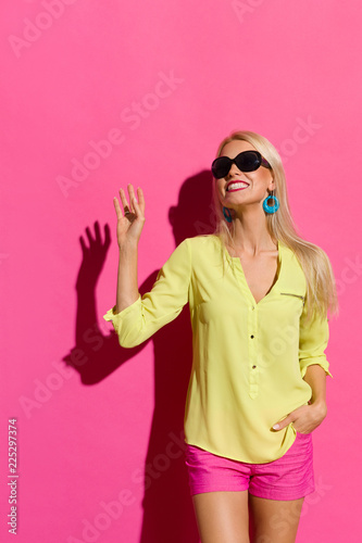Happy Woman In Sunlight Is Looking Away And Waving Hand