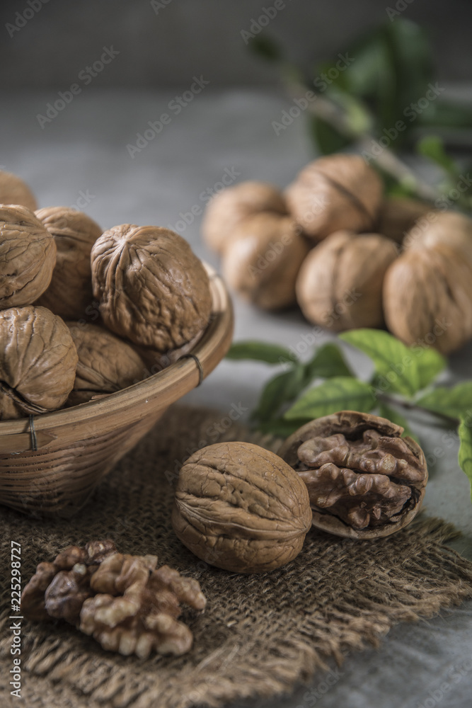 Walnuts in wooden bowl. Whole walnut on table Walnuts in wooden bowl. Whole walnut on table