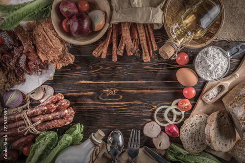 Bread with delicious pieces of sliced ham, sausage, tomatoes, salad and vegetable - Meat platter with selection - Cutting sausage and cured meat photo