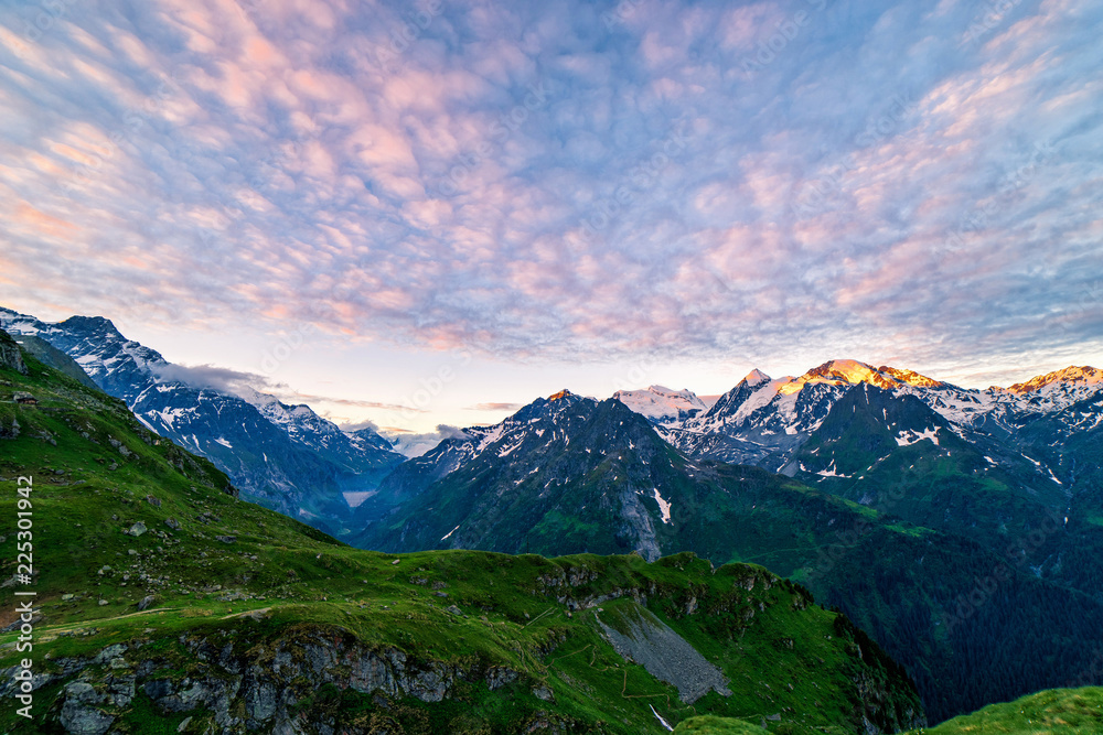 Scenic view of beautiful Swiss Alps mountains. Dramatic early morning scene in high mountains with first light. Blue hour sunrise with pink and blue tones, Switzerland.