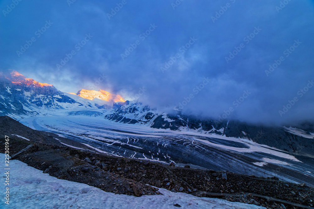 Obraz premium Scenic view of beautiful landscape of Swiss Alps with a majestic Glacier de Corbassiere, Switzerland. Dramatic sunset scene in high mountains.