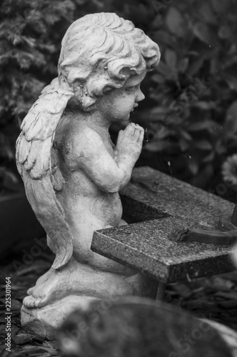 closeup of stoned angel on tomb in a cemetery