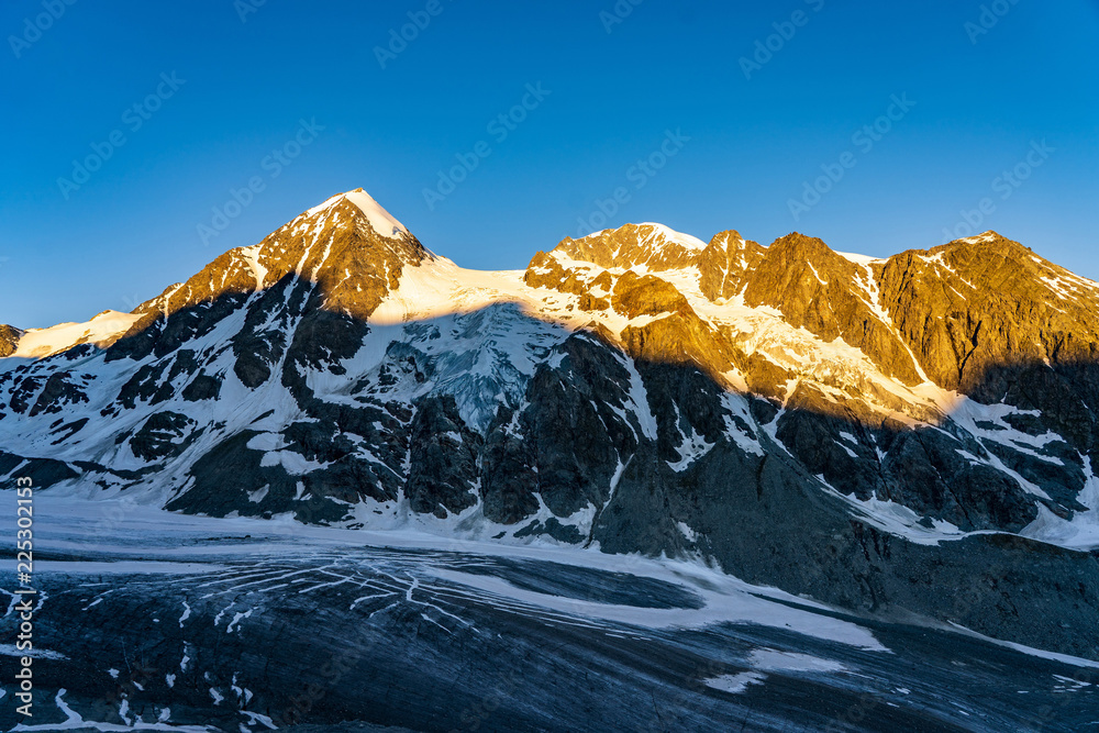 Obraz premium Scenic view of beautiful landscape of Swiss Alps with a majestic Glacier de Corbassiere in a view, Switzerland. Clear sky sunrise in Valais Alps (Pennine Alps.