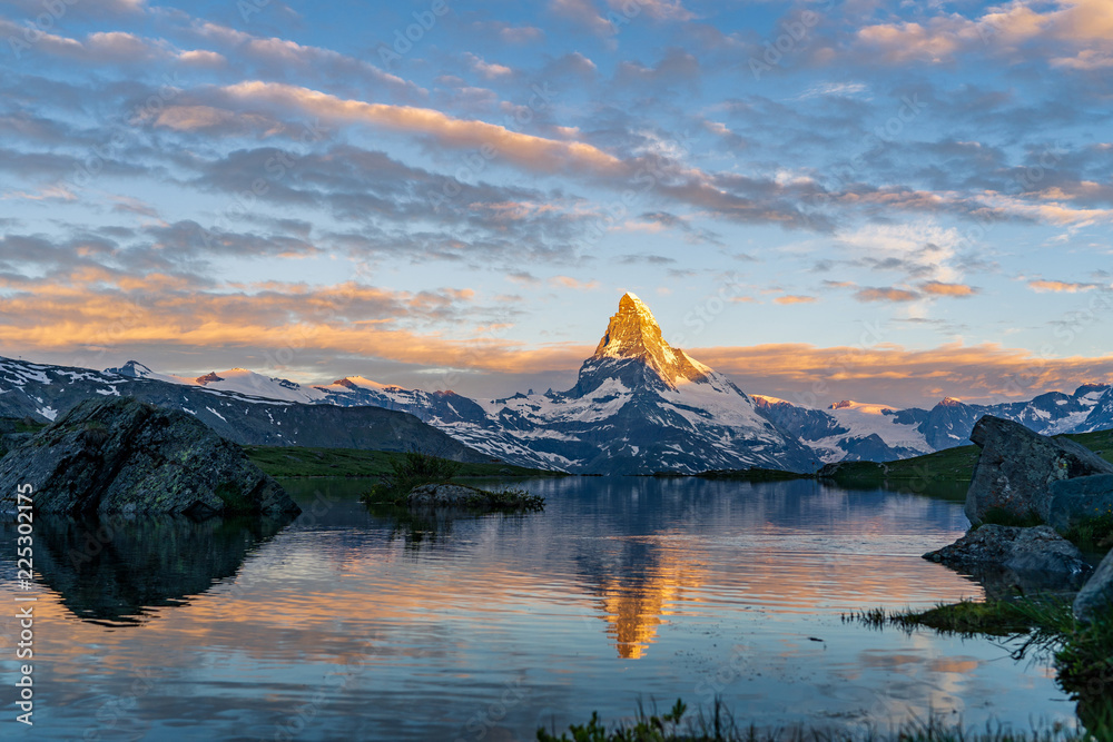Obraz premium Morning shot of the golden Matterhorn (Monte Cervino, Mont Cervin) pyramid and blue Stellisee lake. Sunrise view of majestic mountain landscape. Valais Alps, Zermatt, Switzerland, Europe.