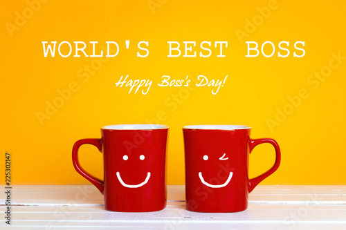 Boss day greeting card with two red coffee mugs with a smiling faces on a yellow background.