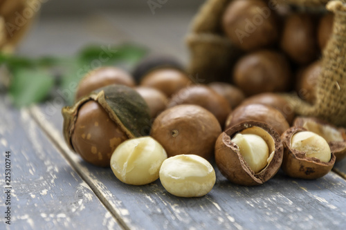 Organic Macadamia nut on wooden table - vintage filter.