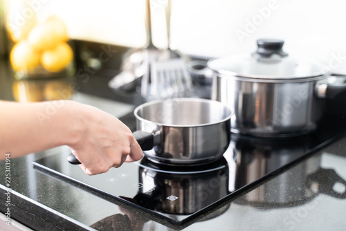 hand holding a pot in the kitchen.