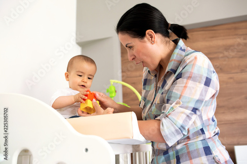 Mother showing her infant how to assemble a toy