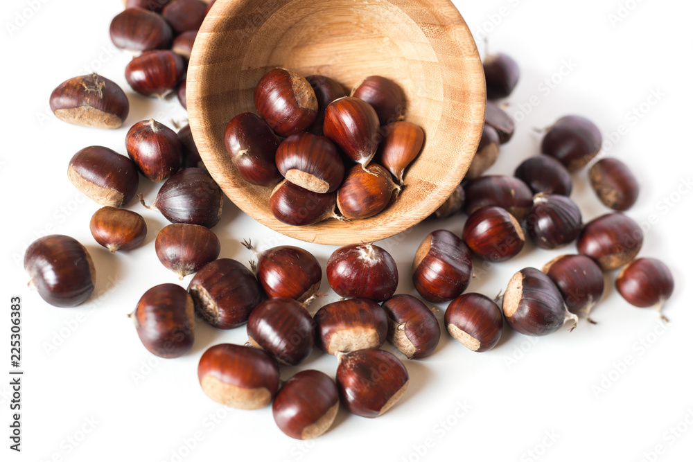 Obraz premium pile of chestnuts in a wooden bowl isolated 