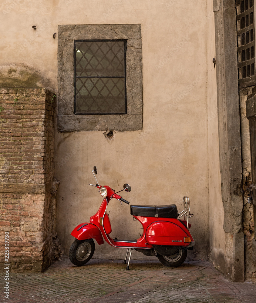 Fototapeta premium Red scooter parked in a side street in Siena, Tuscany