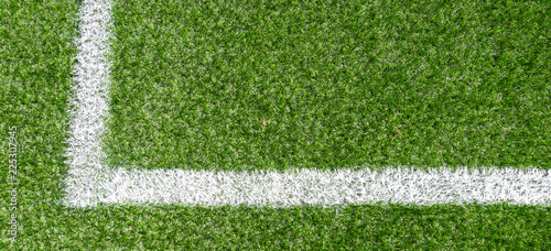 Green synthetic grass soccer sports field with white stripe line