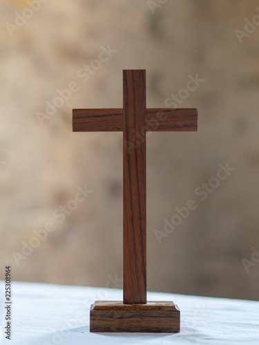 Wooden cross on white altar cloth background. Christian faith.
