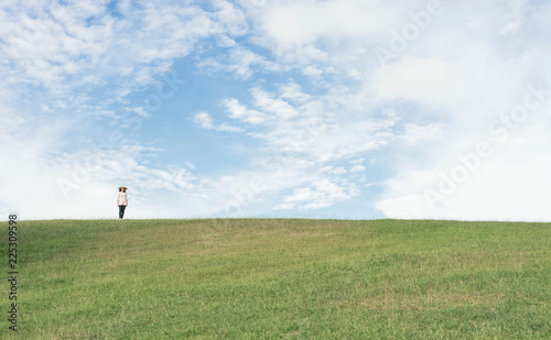 Woman standing on the mountain and looking beautiful sky.