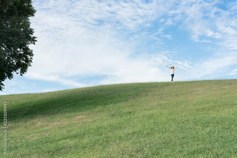 Standing woman raised her hands on the mountain, natural green and beautiful sky. Standing woman raised her hands on the mountain, natural green and beautiful sky.