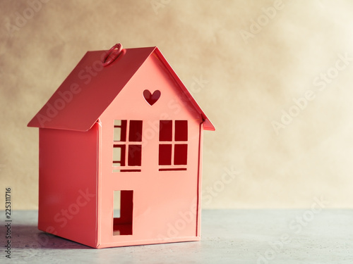 Metal red model of a house with a heart. The concept of home and domestic life. Copy space.
