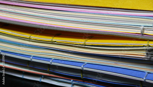 Stack of handmade books with colorful covers and cord binding