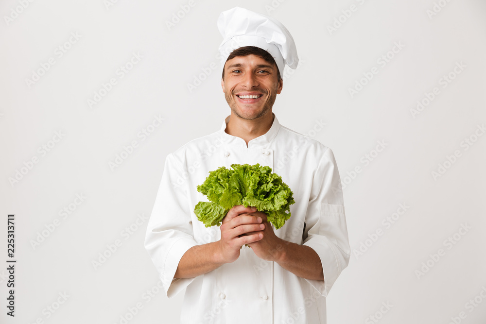 Happy young chef isolated over white background holding salad. Happy young chef isolated over white background holding salad.