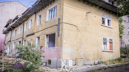 Fototapeta Naklejka Na Ścianę i Meble -  an old urban building destroyed by a natural disaster. a self-destructive building and a house left at random.looted and robbed building.