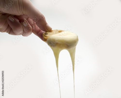 Detale de una mano sosteniendo un pan de pasas tostado con queso fundido 3 photo