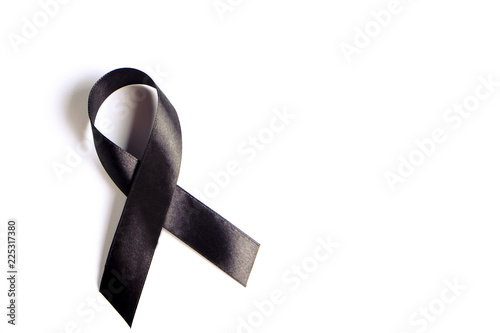 Black ribbon - sign of POW/MIA remembrance and mourning, melanoma awareness, sleep disorders and gang prevention symbol. Isolated on white background, copy space, close up, top view, flat lay.