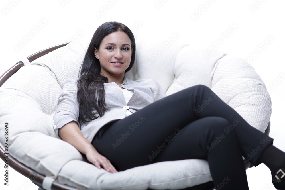 Young woman sitting in a round cozy soft big chair. Young woman sitting in a round cozy soft big chair.