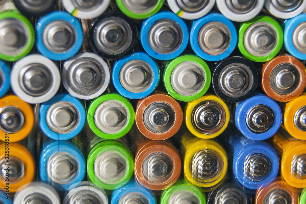 Energy abstract background of colorful batteries.Close-up group of alkaline battery top view. Several batteries in rows, on a mirror surface Energy abstract background of colorful batteries.Close-up group of alkaline battery top view. Several batteries in rows, on a mirror surface