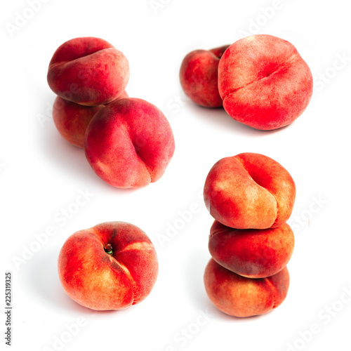 Saturn Peach isolated on white background. A set of flat peaches. Tree doughnut peaches in a pile. photo