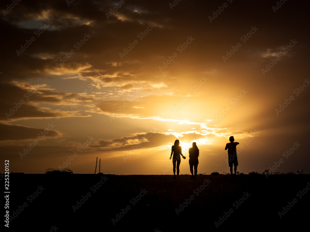 Human silhouettes with sunset background
