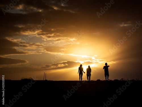 Human silhouettes with sunset background