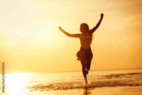 Happy girl run in sunset lake photo