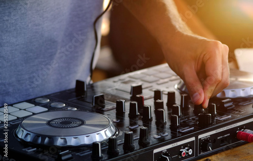DJ plays and mix music on digital midi controller.