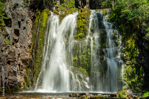Beautiful waterfall flowing down a green rock wall
