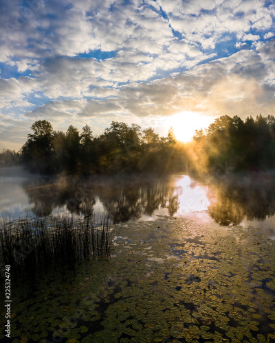 Sunrise in the morning above river Mreznica, beautiful reflections, sun rays, beautiful clouds, Croatia