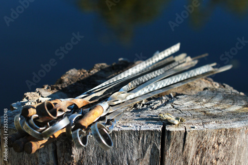 Old metal skewers on wooden background photo