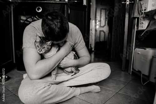 Мужчина обнимает кошку после операции